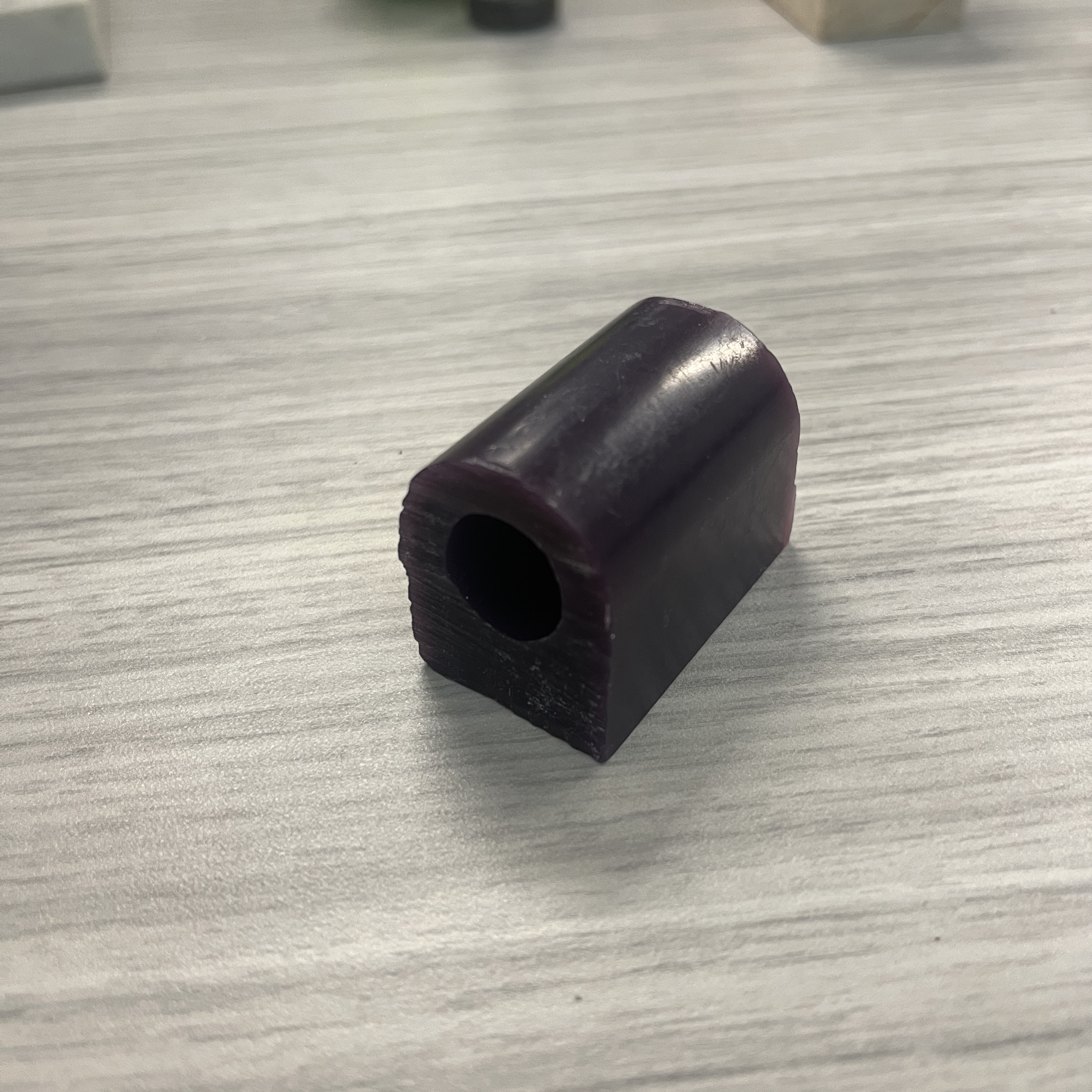 This object is a piece of heavy plastic. it's texture is very smooth, adn visually reflective of rough light. it's surprisingly heavy for it's size, too.